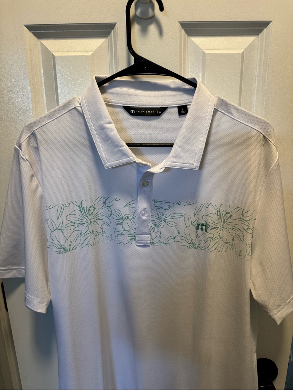 Travis Mathew White Polo with Mint Floral Chest Stripe